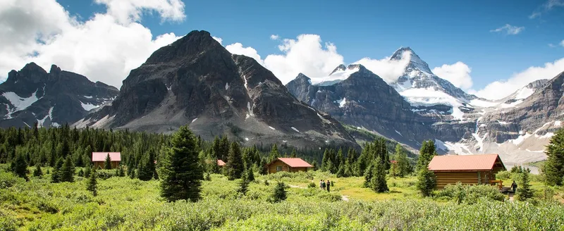 Lodge cabins nestled by Lake Magog with Mount Assiniboine backdrop