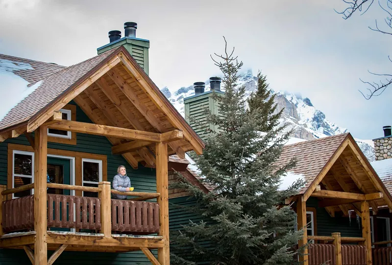 Buffalo Mountain Lodge timber cabins with snow-capped peaks in winter landscape.