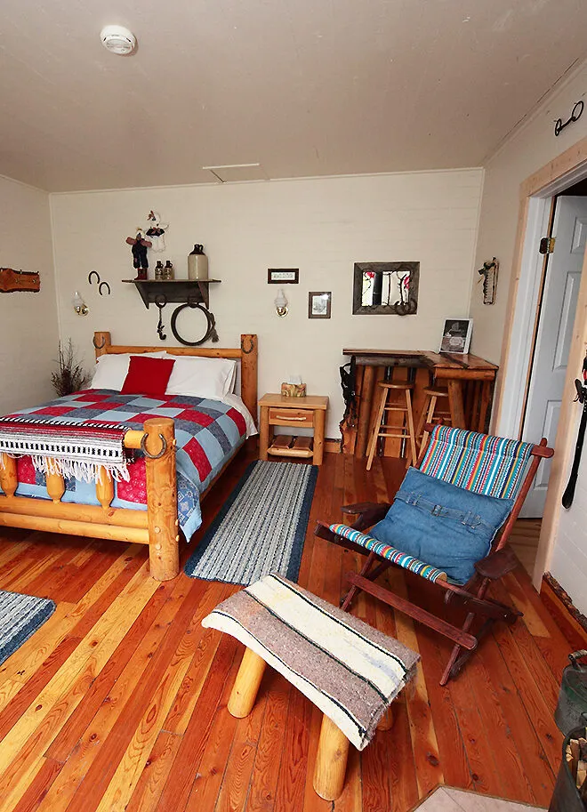 Cross River Wilderness Centre cabin interior with rustic wood furnishings and colorful bedding.