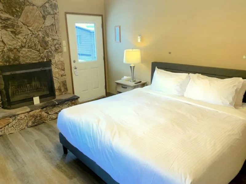 Sunwapta Falls Lodge king cabin with stone fireplace, queen bed, and interior door access.